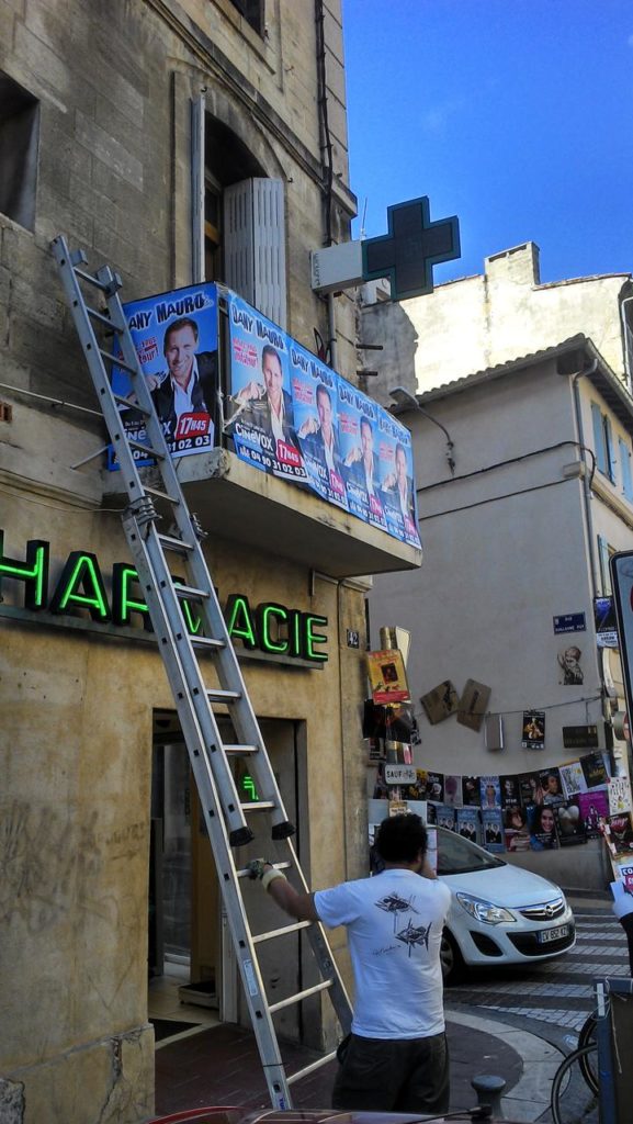 Pose d'affiches sur les balcons à Avignon pour le spectacle de Dany Mauro