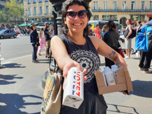 Distribution publicitaire d'échantillons de bouteille d'eau de la marque Eau Neuve dans la rue à Paris par une agence de street marketing.