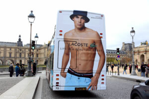 Affichage sur les arrières des red bus touristiques à impériale dans le Jardin des Tuileries près du Louvre à Paris.