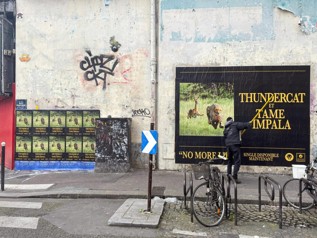 Collage d'affiches en sauvage au format 4 x 3 m sur les murs à Paris.