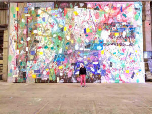Joris Brantuas devant une peinture 8 x 15 m à l'exposition personnelle "Arlequin" à Sète (été 2018) dans les établissements Larosa.
