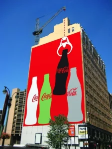 Installation street guerilla marketing sur un mur d'une publicité, évènementielle et spectaculaire, pour la marque Coca-Cola.