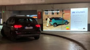 Affichage de publicité dans un parking sur la voie de descente des voitures dans le centre ville d'Aix-en-Provence.
