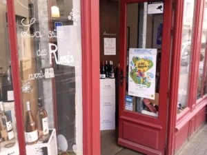 Affiche « Cet été à Rennes » dans un cadre protégé sur la devanture d'une cave à vins en centre-ville