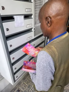 Un agent de Street Dispatch distribuant des flyers dans des boîtes aux lettres d'un immeuble.